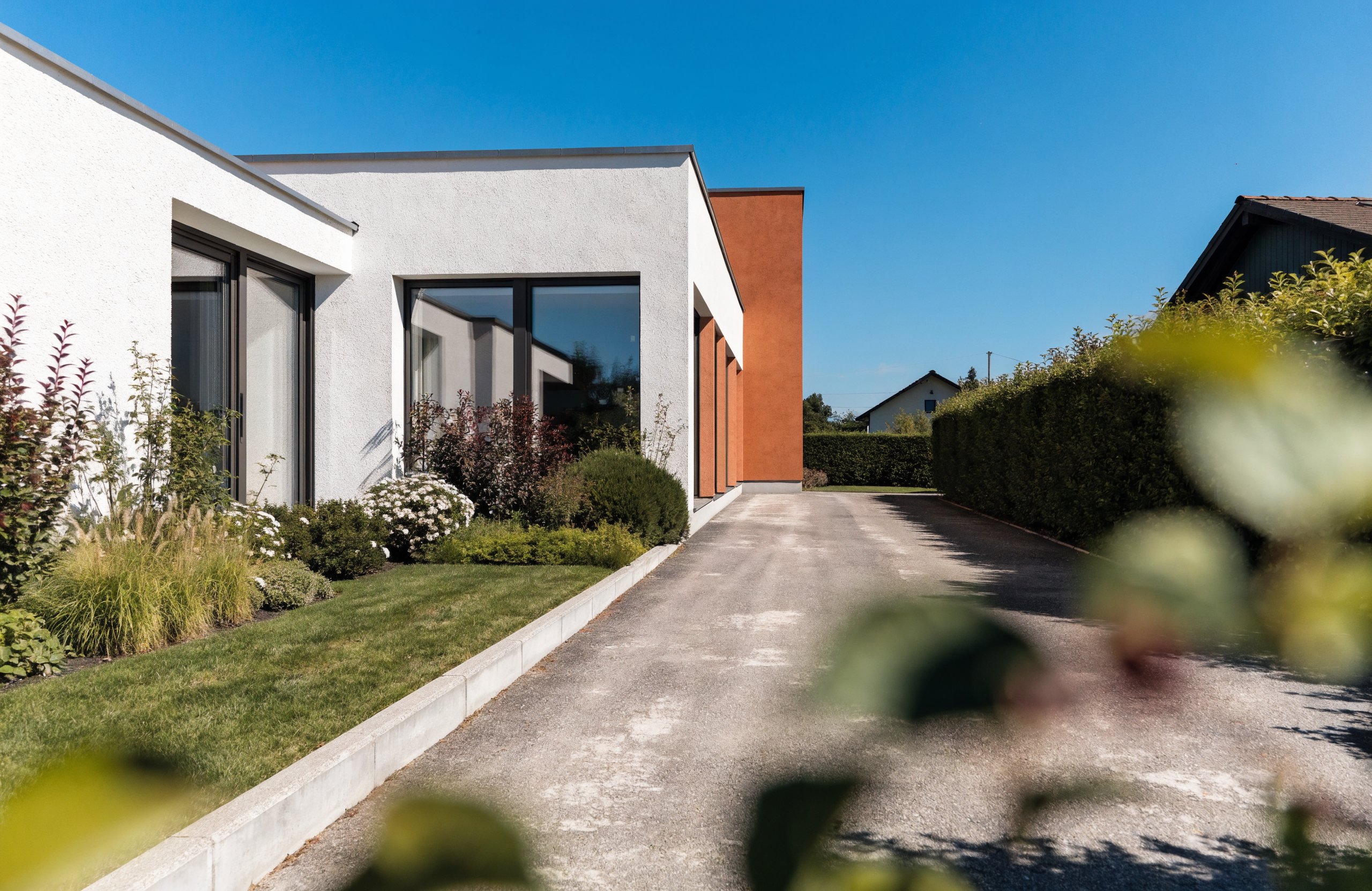 Modernes Massivhaus mit weißer Putzfassade und Garten – Wertbeständigkeit von Massivhäusern